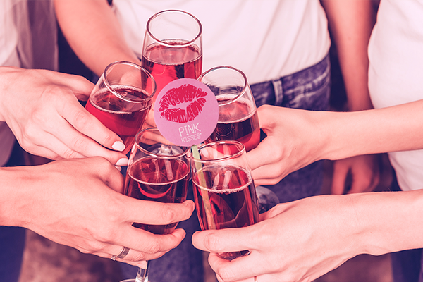 Cheers! Five girl friends chink glasses with a pink drink drink